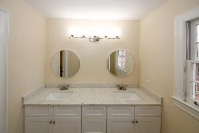 bathroom featuring a sink and double vanity