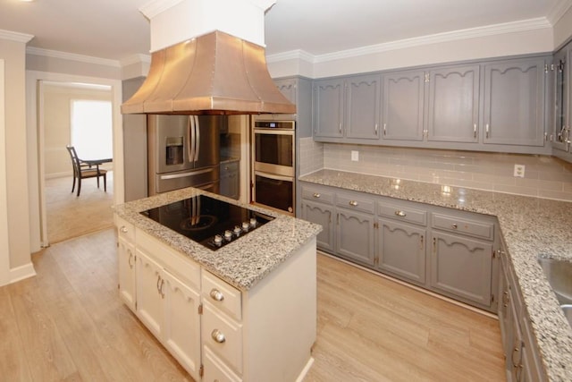 kitchen with appliances with stainless steel finishes, island exhaust hood, and gray cabinetry