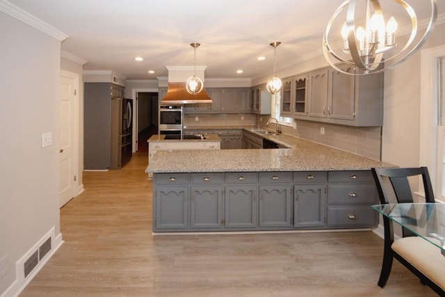 kitchen featuring gray cabinets, visible vents, appliances with stainless steel finishes, a sink, and light wood-type flooring