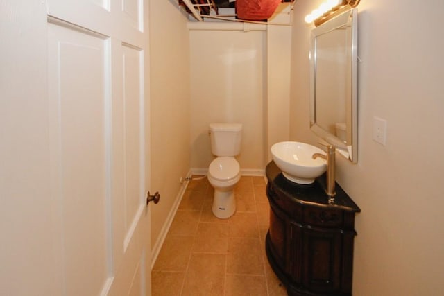 bathroom featuring toilet, vanity, baseboards, and tile patterned floors