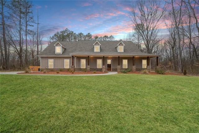 view of front of home with covered porch, board and batten siding, and a front yard