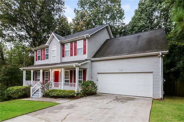 view of front facade with a porch, a front yard, and a garage