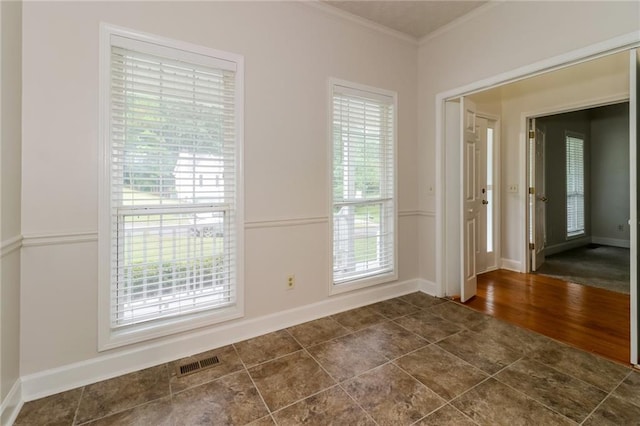 empty room with crown molding, dark hardwood / wood-style floors, and a wealth of natural light