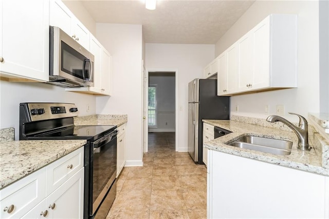 kitchen featuring light stone counters, appliances with stainless steel finishes, sink, and white cabinets