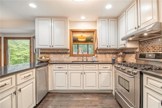 2452 Camp Mitchell Rd, Grayson, GA 30017 - kitchen featuring stainless steel appliances, under cabinet range hood, a sink, dark wood finished floors, and backsplash