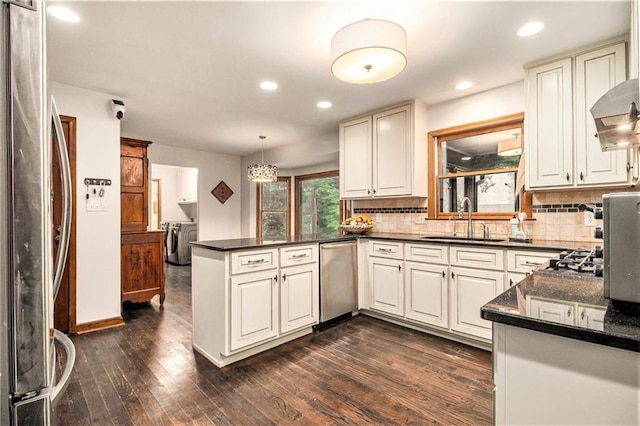 2452 Camp Mitchell Rd, Grayson, GA 30017 - kitchen with a sink, washing machine and dryer, stainless steel appliances, dark countertops, and a peninsula