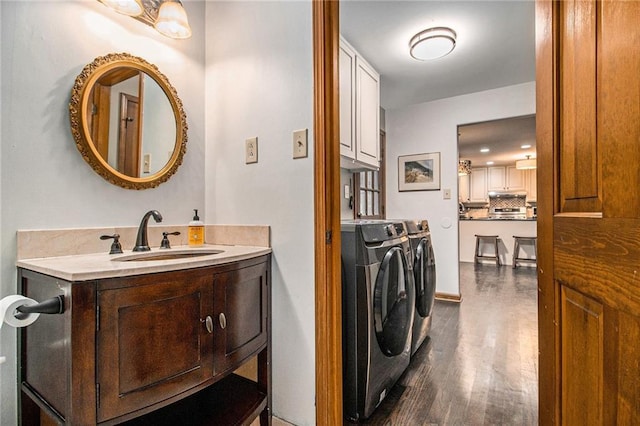 2452 Camp Mitchell Rd, Grayson, GA 30017 - bathroom with washing machine and clothes dryer, wood finished floors, vanity, and decorative backsplash