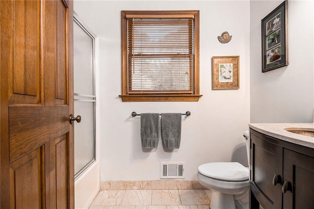 2452 Camp Mitchell Rd, Grayson, GA 30017 - bathroom with marble look tile flooring, vanity, toilet, baseboards, and shower / bath combination with glass door