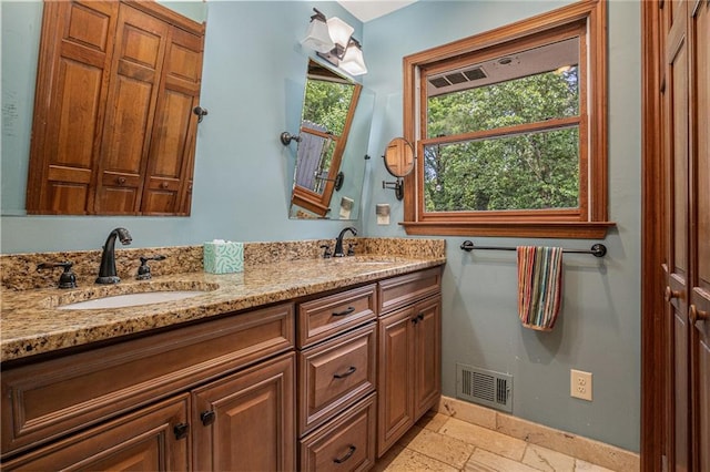 2452 Camp Mitchell Rd, Grayson, GA 30017 - bathroom with double vanity, stone tile floors, and baseboards