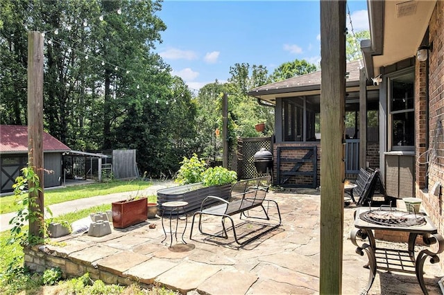 2452 Camp Mitchell Rd, Grayson, GA 30017 - view of patio featuring a fire pit and a sunroom