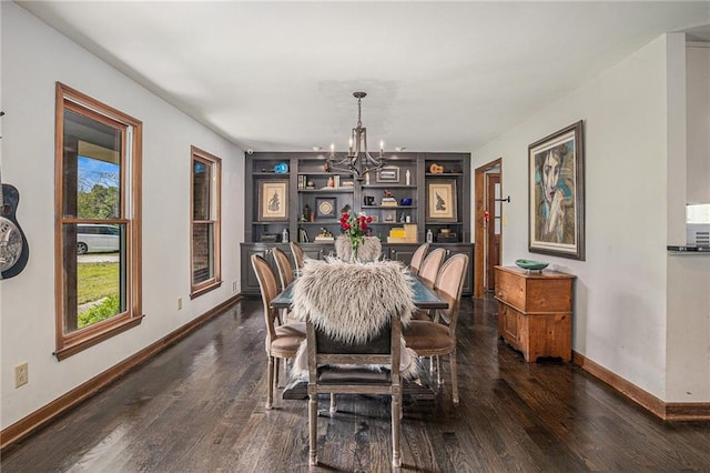 2452 Camp Mitchell Rd, Grayson, GA 30017 - dining space featuring a chandelier, baseboards, dark wood finished floors, and built in features