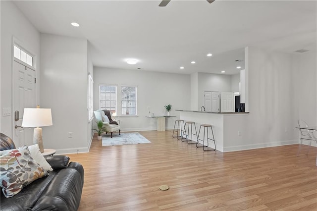 living room with ceiling fan and light hardwood / wood-style floors