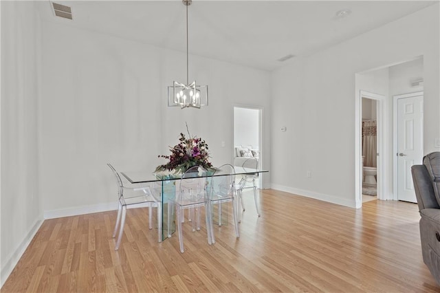 dining space featuring an inviting chandelier and light hardwood / wood-style flooring