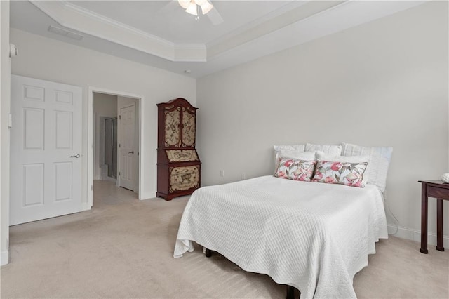 carpeted bedroom with ceiling fan, crown molding, and a tray ceiling