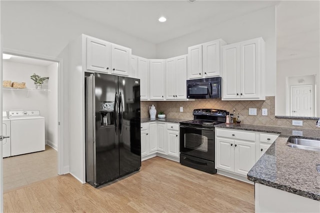 kitchen featuring white cabinetry, light hardwood / wood-style floors, tasteful backsplash, washing machine and dryer, and black appliances