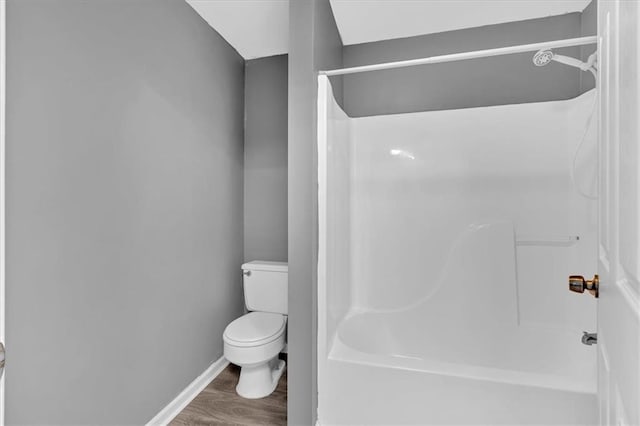 bathroom featuring hardwood / wood-style flooring, toilet, and walk in shower