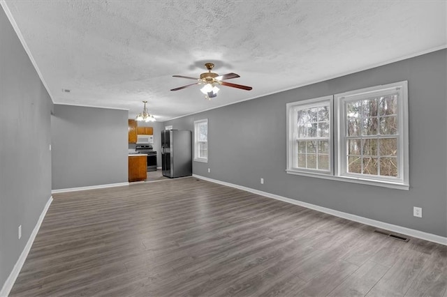 unfurnished living room featuring dark wood-type flooring, ornamental molding, ceiling fan with notable chandelier, and a textured ceiling