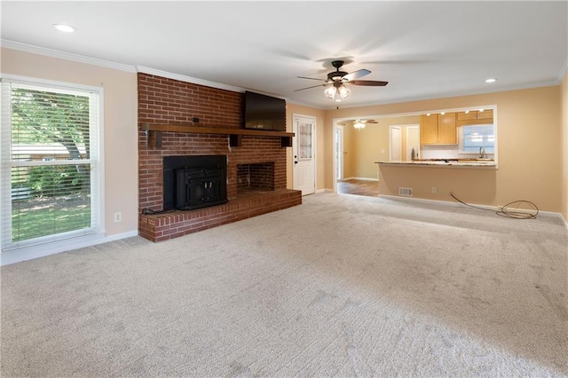 unfurnished living room with crown molding, a ceiling fan, baseboards, and carpet floors
