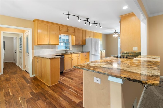 kitchen with freestanding refrigerator, a peninsula, black electric cooktop, a ceiling fan, and dark stone countertops