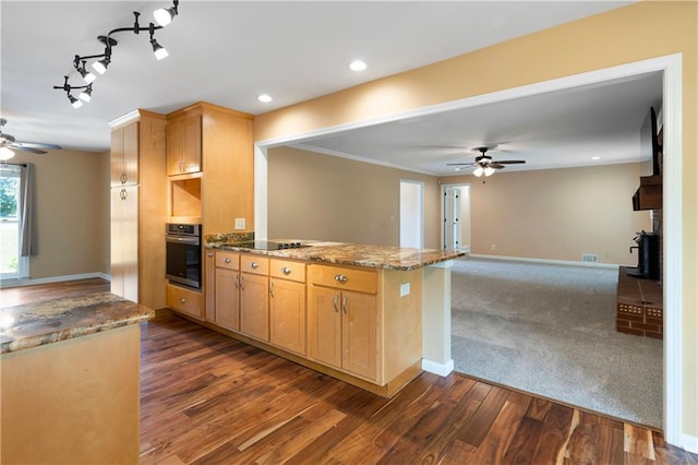 kitchen with stone counters, ceiling fan, stainless steel oven, and a peninsula