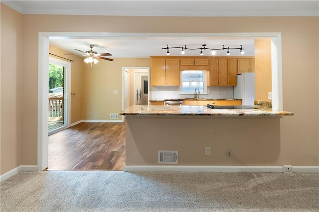 kitchen with carpet floors, freestanding refrigerator, stainless steel dishwasher, baseboards, and a sink