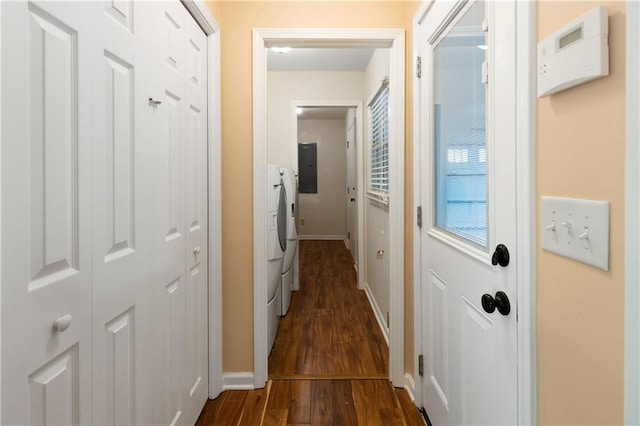 corridor featuring baseboards, electric panel, washing machine and dryer, and dark wood-type flooring