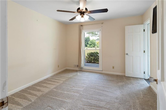 spare room with visible vents, a ceiling fan, baseboards, and light carpet