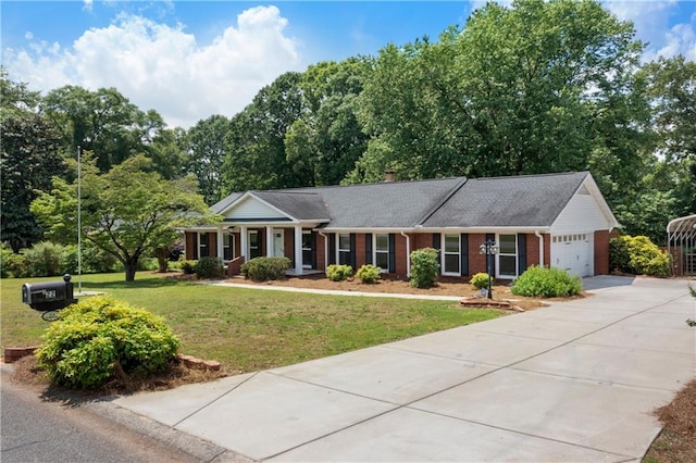 view of front facade with a front lawn, brick siding, a garage, a chimney, and driveway