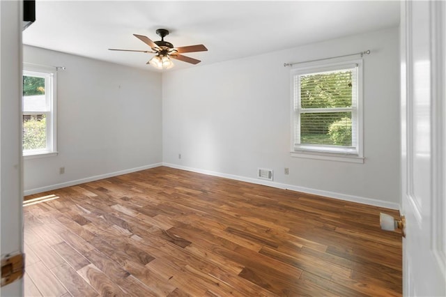 unfurnished room featuring visible vents, a ceiling fan, baseboards, and wood finished floors