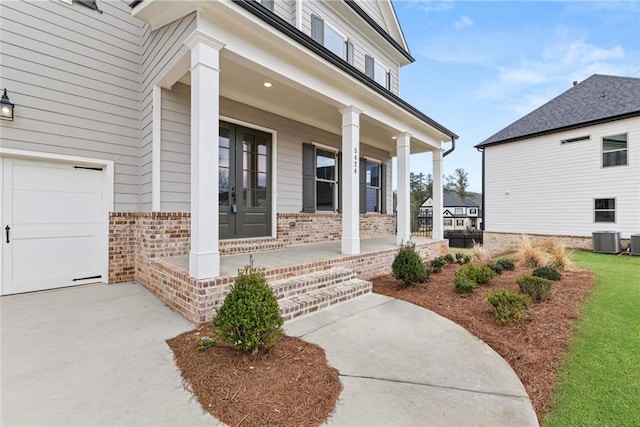 5424 Gallagher Ct, Powder Springs, GA 30127 - view of exterior entry featuring covered porch, brick siding, central AC, and a garage