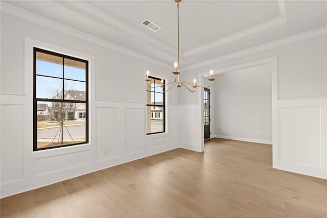 5424 Gallagher Ct, Powder Springs, GA 30127 - unfurnished dining area with a decorative wall, a chandelier, a raised ceiling, ornamental molding, and light wood finished floors