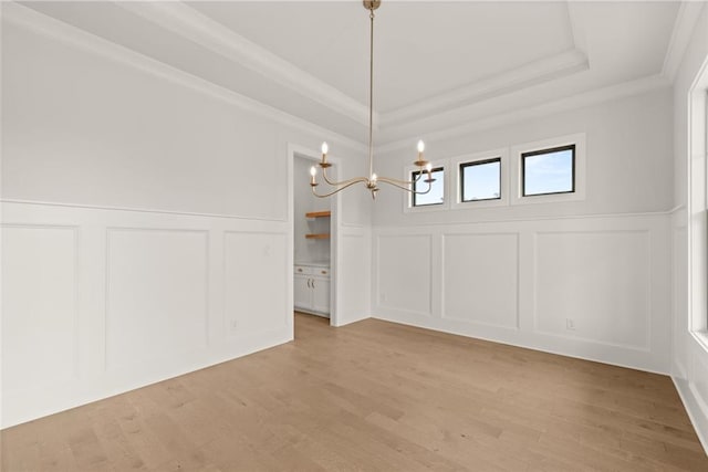 5424 Gallagher Ct, Powder Springs, GA 30127 - unfurnished dining area featuring a decorative wall, a chandelier, ornamental molding, light wood-style flooring, and a tray ceiling