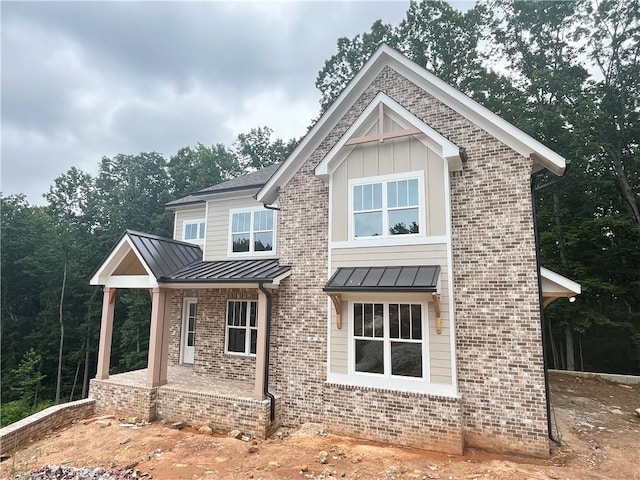 1025 Liberty Springs Dr, Woodstock, GA 30188 - view of front of home featuring a standing seam roof, brick siding, a metal roof, and a porch