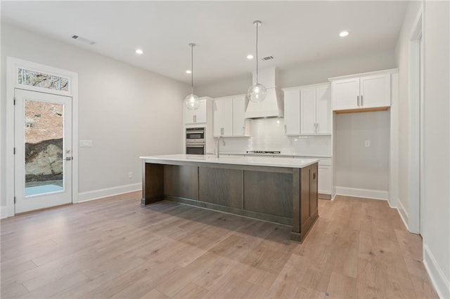 1025 Liberty Springs Dr, Woodstock, GA 30188 - kitchen with white cabinets, backsplash, light wood finished floors, light countertops, and recessed lighting
