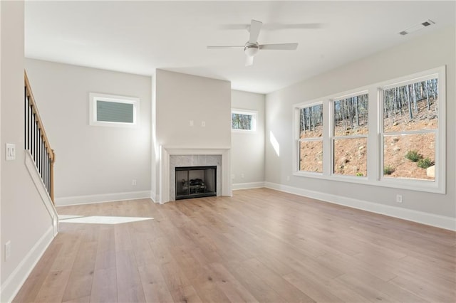 1025 Liberty Springs Dr, Woodstock, GA 30188 - unfurnished living room with a ceiling fan, light wood-style flooring, a fireplace, and stairs