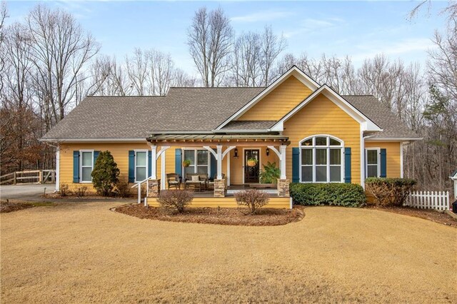 back of house featuring a porch, driveway, a shingled roof, and fence