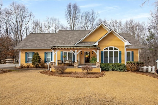 back of house with covered porch, roof with shingles, fence, and driveway