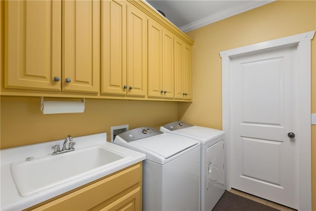 laundry room with washing machine and clothes dryer, a sink, cabinet space, and crown molding