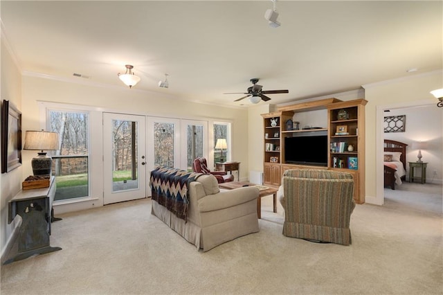 living room with light carpet, ornamental molding, and a healthy amount of sunlight