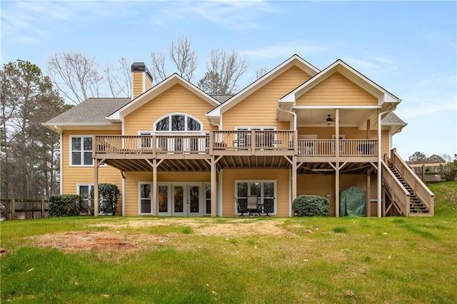 rear view of property with a ceiling fan, stairway, a lawn, and a deck