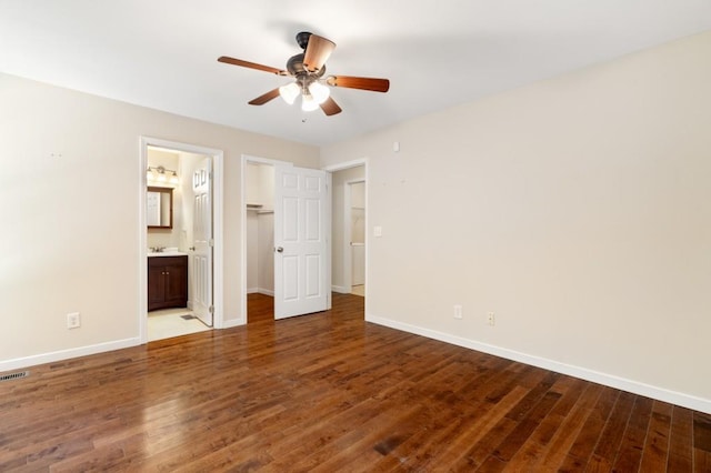 unfurnished bedroom featuring hardwood / wood-style floors, ceiling fan, and ensuite bath