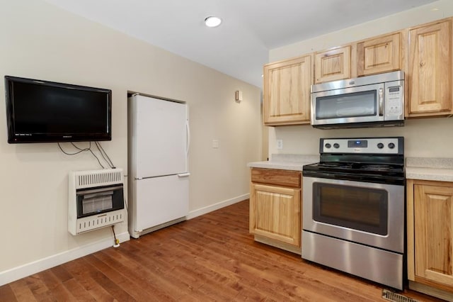 kitchen featuring light brown cabinets, light wood-type flooring, appliances with stainless steel finishes, and heating unit