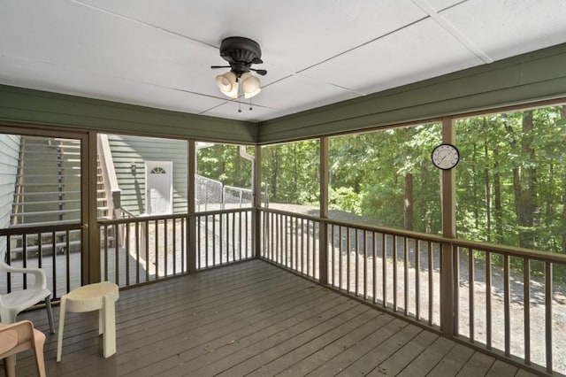 unfurnished sunroom featuring ceiling fan