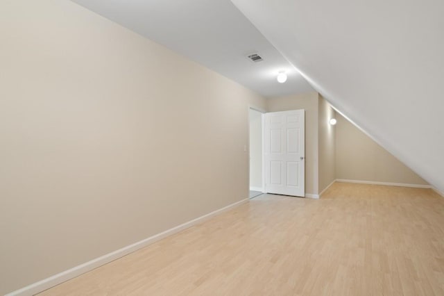 bonus room with light hardwood / wood-style floors and vaulted ceiling