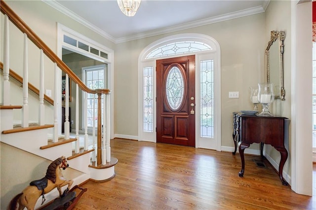 foyer featuring hardwood / wood-style floors and crown molding