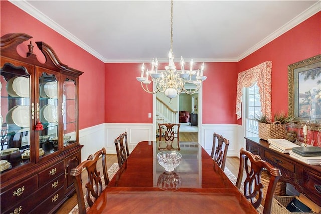 dining area with ornamental molding, a chandelier, and wood-type flooring