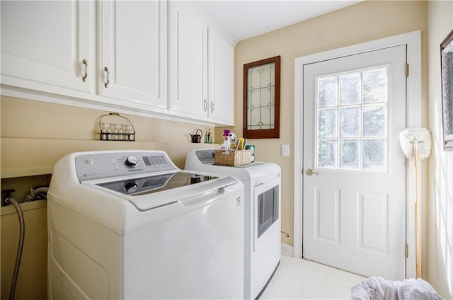 laundry room featuring washer and dryer and cabinets