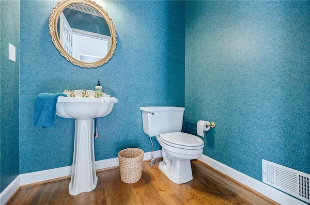 bathroom with hardwood / wood-style flooring and toilet