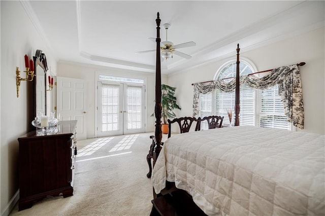 carpeted bedroom featuring ceiling fan, french doors, multiple windows, and a tray ceiling