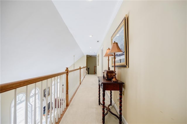 hall featuring crown molding, light colored carpet, and vaulted ceiling